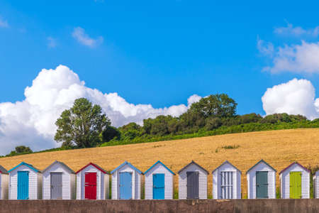 Colourful beach houses. Row of multicolored beach huts against blue sky.の写真素材