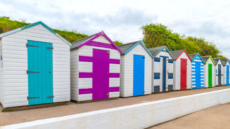 Colourful beach houses. Row of multicolored beach huts against blue sky.の写真素材