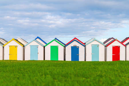 Colourful beach houses. Row of multicolored beach huts against blue sky.の写真素材