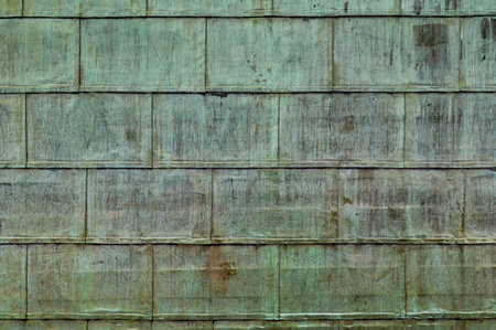 Oxidized copper folded sheet metal on roof. Copper wall texture background with marks and scrawls.の写真素材