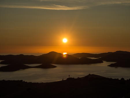 Aerial panoramic view of sunset above the islands in Croatia with many sailing yachts between, duak in Kornati national park landscape in the Mediterranean seaの写真素材