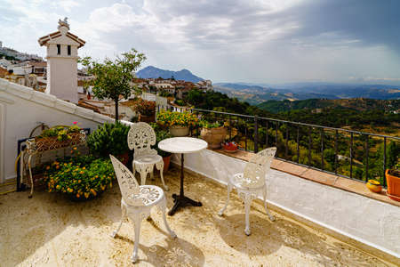 TÃ­tulo: terrace with white chairs and table with landscape in the backgroundの写真素材