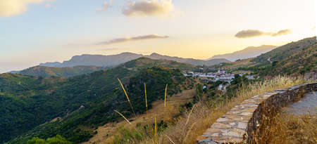panoramic photo of white village with low wall in the foreground and mountains and blue sky in the background with mountainsの写真素材