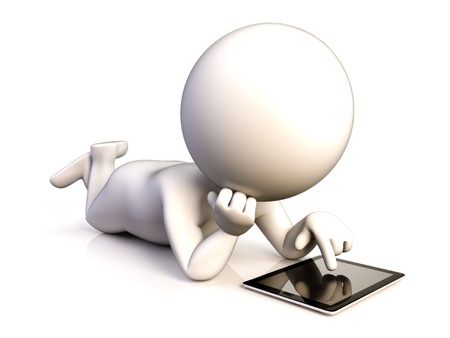 A person enjoying his tablet lying on the groundの写真素材