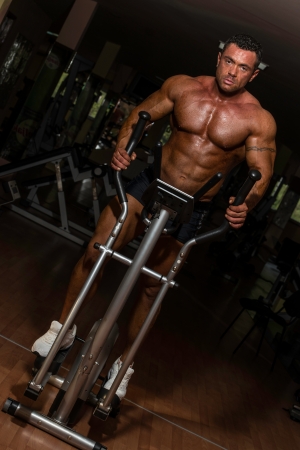 male bodybuilder using the elliptical machineの写真素材