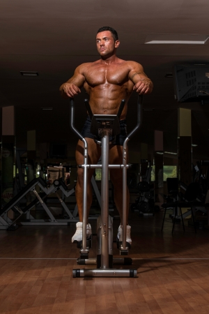 male bodybuilder using the elliptical machineの写真素材