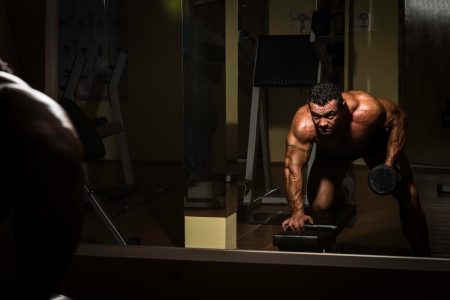 male bodybuilder doing heavy weight exercise for backの写真素材