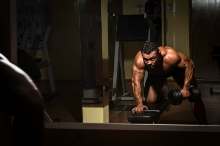 male bodybuilder doing heavy weight exercise for backの写真素材