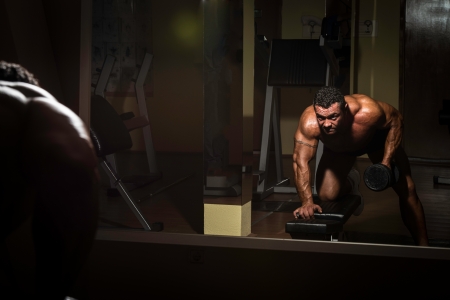male bodybuilder doing heavy weight exercise for backの写真素材