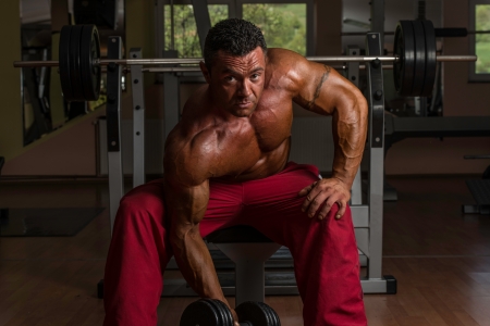shirtless bodybuilder doing heavy weight exercise for bicepsの写真素材