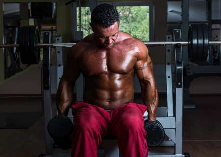 shirtless bodybuilder doing heavy weight exercise for bicepsの写真素材