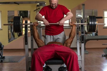 training in gym where partner gives encouragementの写真素材