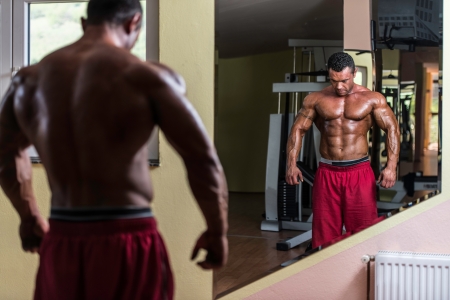 shirtless bodybuilder posing at the mirrorの写真素材