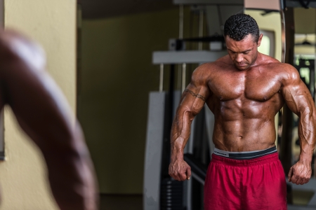 shirtless bodybuilder posing at the mirrorの写真素材
