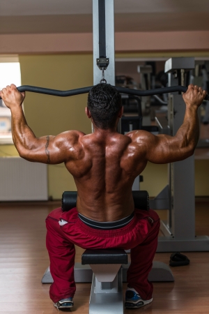 shirtless bodybuilder doing heavy weight exercise for backの写真素材