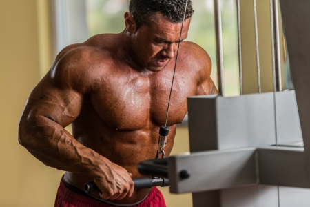 bodybuilder doing heavy weight exercise for triceps with cableの写真素材