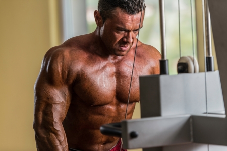bodybuilder doing heavy weight exercise for triceps with cableの写真素材