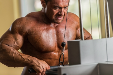 bodybuilder doing heavy weight exercise for triceps with cableの写真素材
