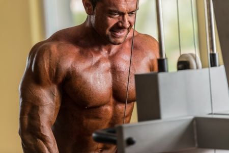 bodybuilder doing heavy weight exercise for triceps with cableの写真素材