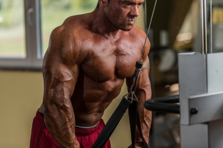 bodybuilder doing heavy weight exercise for triceps with cableの写真素材