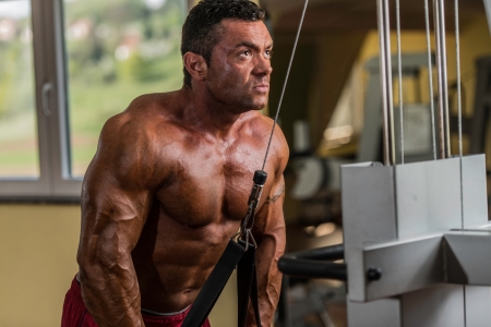 bodybuilder doing heavy weight exercise for triceps with cableの写真素材