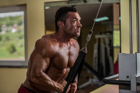 bodybuilder doing heavy weight exercise for triceps with cableの写真素材