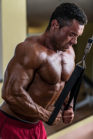 bodybuilder doing heavy weight exercise for triceps with cableの写真素材