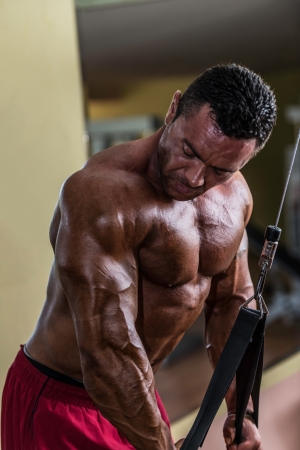bodybuilder doing heavy weight exercise for triceps with cableの写真素材