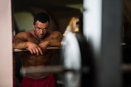 bodybuilder resting after doing heavy weight exerciseの写真素材