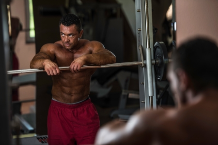bodybuilder resting after doing heavy weight exerciseの写真素材