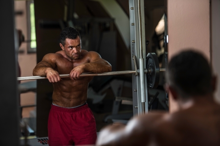 bodybuilder resting after doing heavy weight exerciseの写真素材