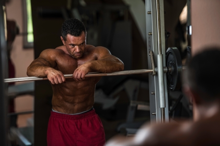 bodybuilder resting after doing heavy weight exerciseの写真素材