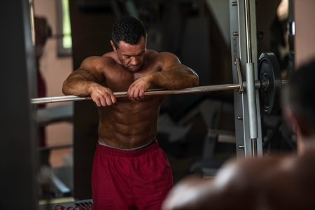 bodybuilder resting after doing heavy weight exerciseの写真素材
