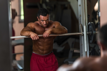 bodybuilder resting after doing heavy weight exerciseの写真素材