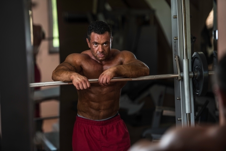 bodybuilder resting after doing heavy weight exerciseの写真素材