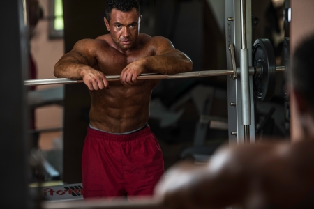 bodybuilder resting after doing heavy weight exerciseの写真素材