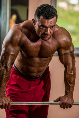 bodybuilder resting after doing heavy weight exerciseの写真素材