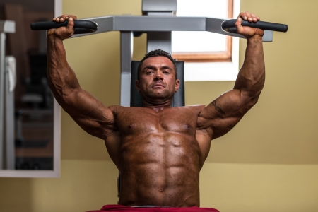 male bodybuilder doing heavy weight exercise for upper chestの写真素材