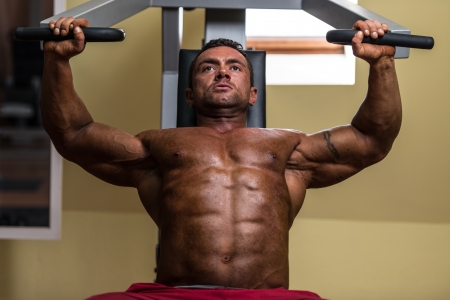 male bodybuilder doing heavy weight exercise for upper chestの写真素材
