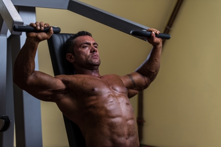 male bodybuilder doing heavy weight exercise for upper chestの写真素材