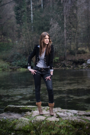 young woman in jacket standing and posing at the lakeの写真素材