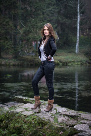 young woman in jacket standing and posing at the lakeの写真素材