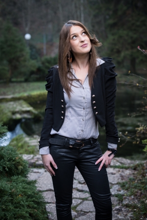 young woman in jacket standing and posing at the lakeの写真素材