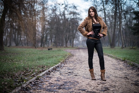 young woman in jacket standing and posing at the forestの写真素材
