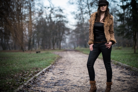young woman in jacket standing and posing at the forestの写真素材