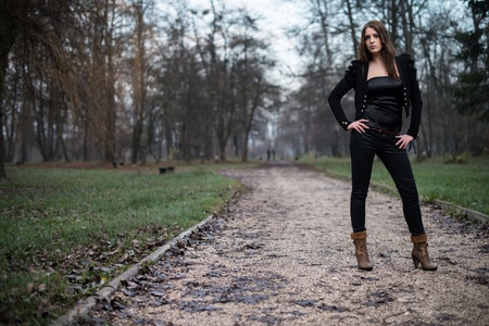 young woman in jacket standing and posing at the forestの写真素材