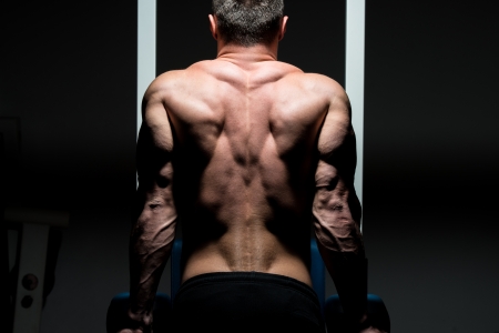 young male bodybuilder doing heavy weight exerciseの写真素材