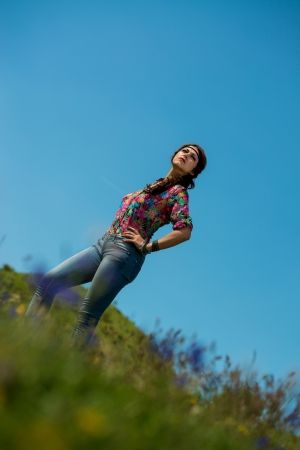 beautiful woman in jeans standing on the grassの写真素材