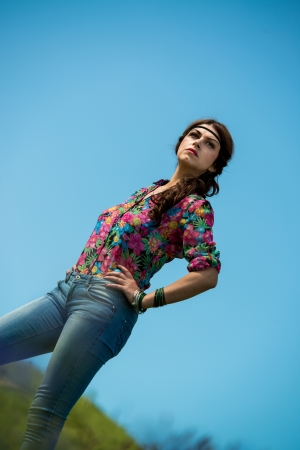 beautiful woman in jeans standing on the grassの写真素材