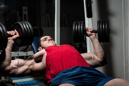young bodybuilder doing bench press for chestの写真素材